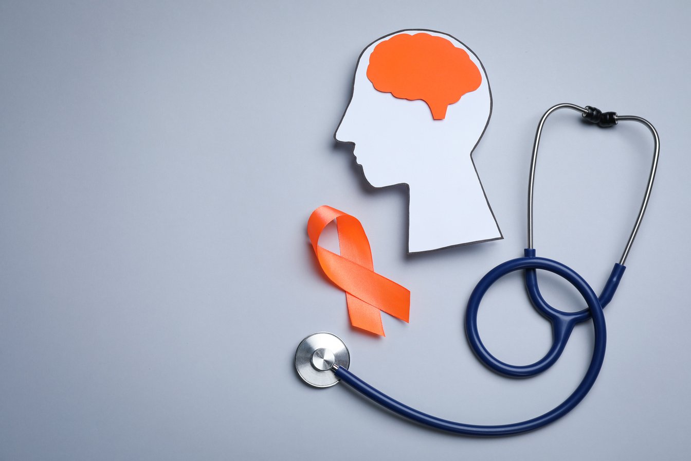 Human Head Cutout, Brain, Orange Ribbon and Stethoscope on Grey Background, Flat Lay with Space for Text. Multiple Sclerosis Concept